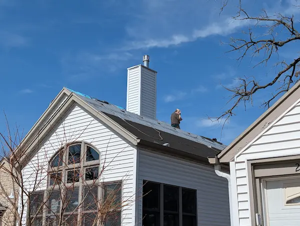 Residential roof replacement around a large chimney